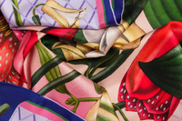 Close-up image of 100% silk square scarf featuring a vivid floral collage of soft lilac, scarlet, and bubblegum. illustrates the lightly ridged texture of the silk twill along with the rich color tones and luminous nature of the silk scarf. 