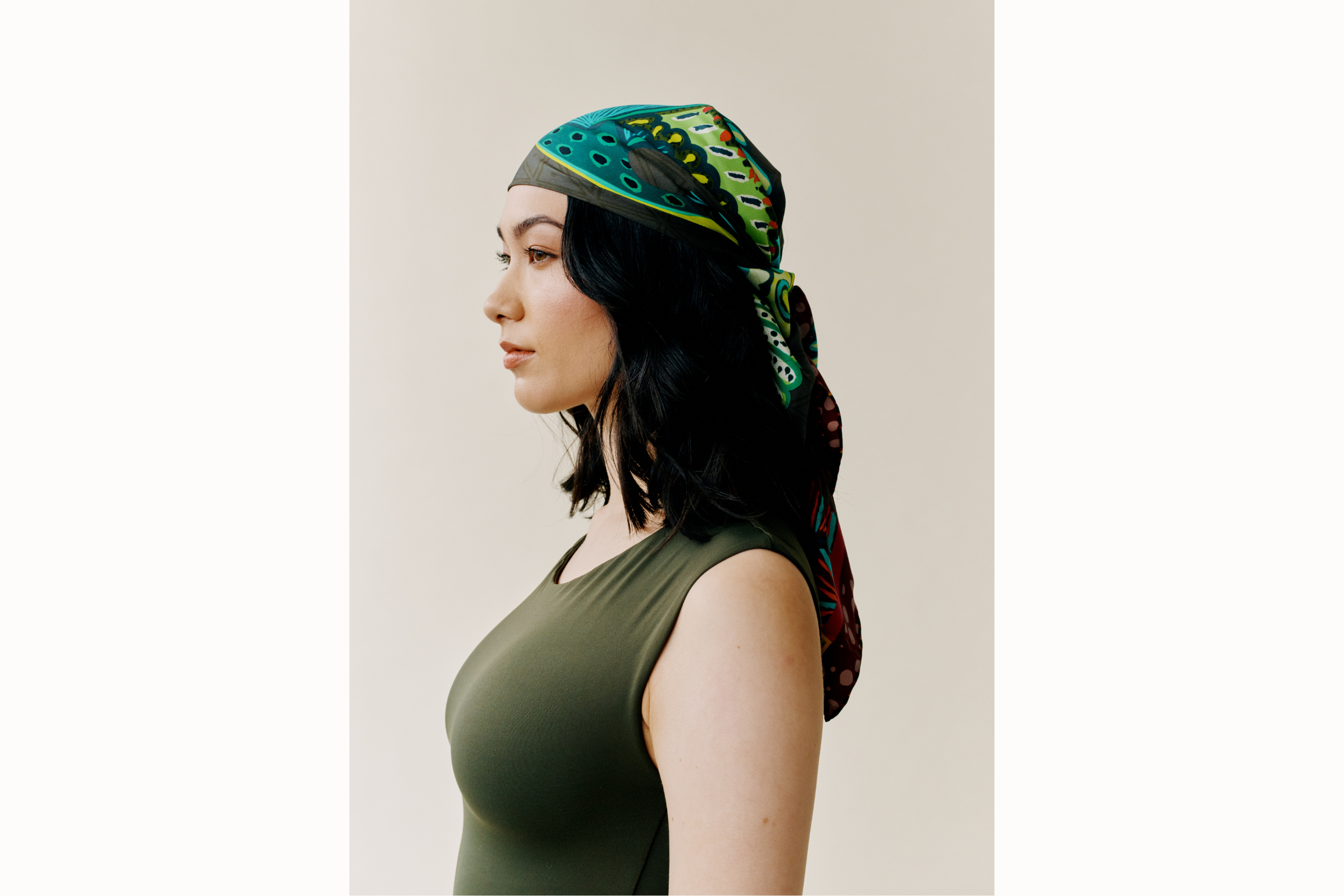 Side profile of the model wearing scarf styled as a headscarf. 