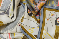 Up close image image of 100% silk square scarf featuring rectilinear geometry, intricate line art, and aerodynamic curves in shades of cream and soft gray with pops of pink and metallic tones