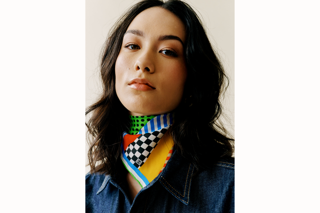 Image of female model wearing the scarf tied as a bandana with scarf draping over front of the base of her neck.