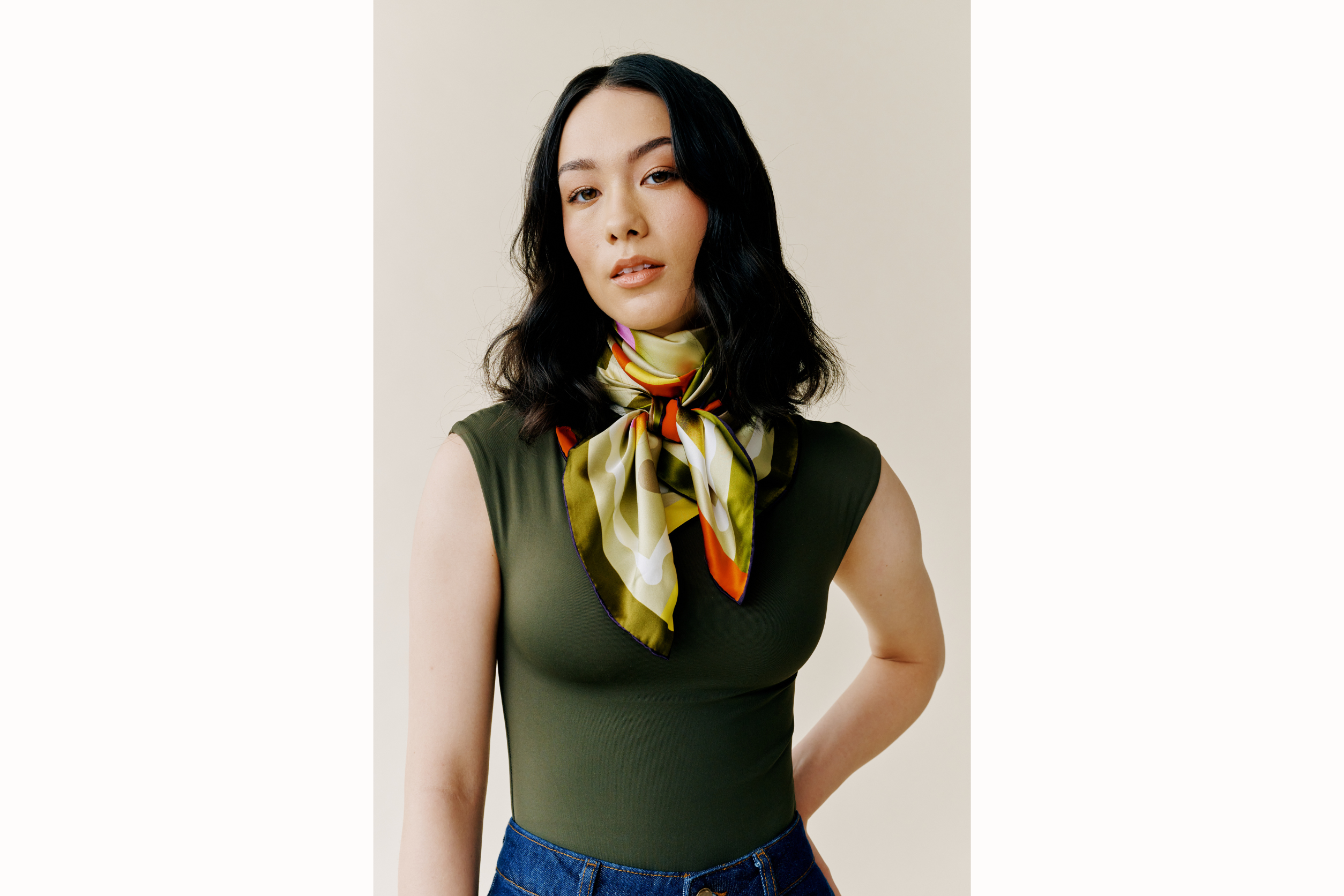 Model has her hand on her hip and wears the scarf styled in a cowgirl knot.