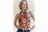 Image of female model wearing scarf tied together at the neck and bottom of the back to create a top.