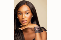 Image of female model wearing the wrapped around her wrist and secured with a simple knot to create a silk bracelet. The model is also wearing a chocolate brown silk tank top.