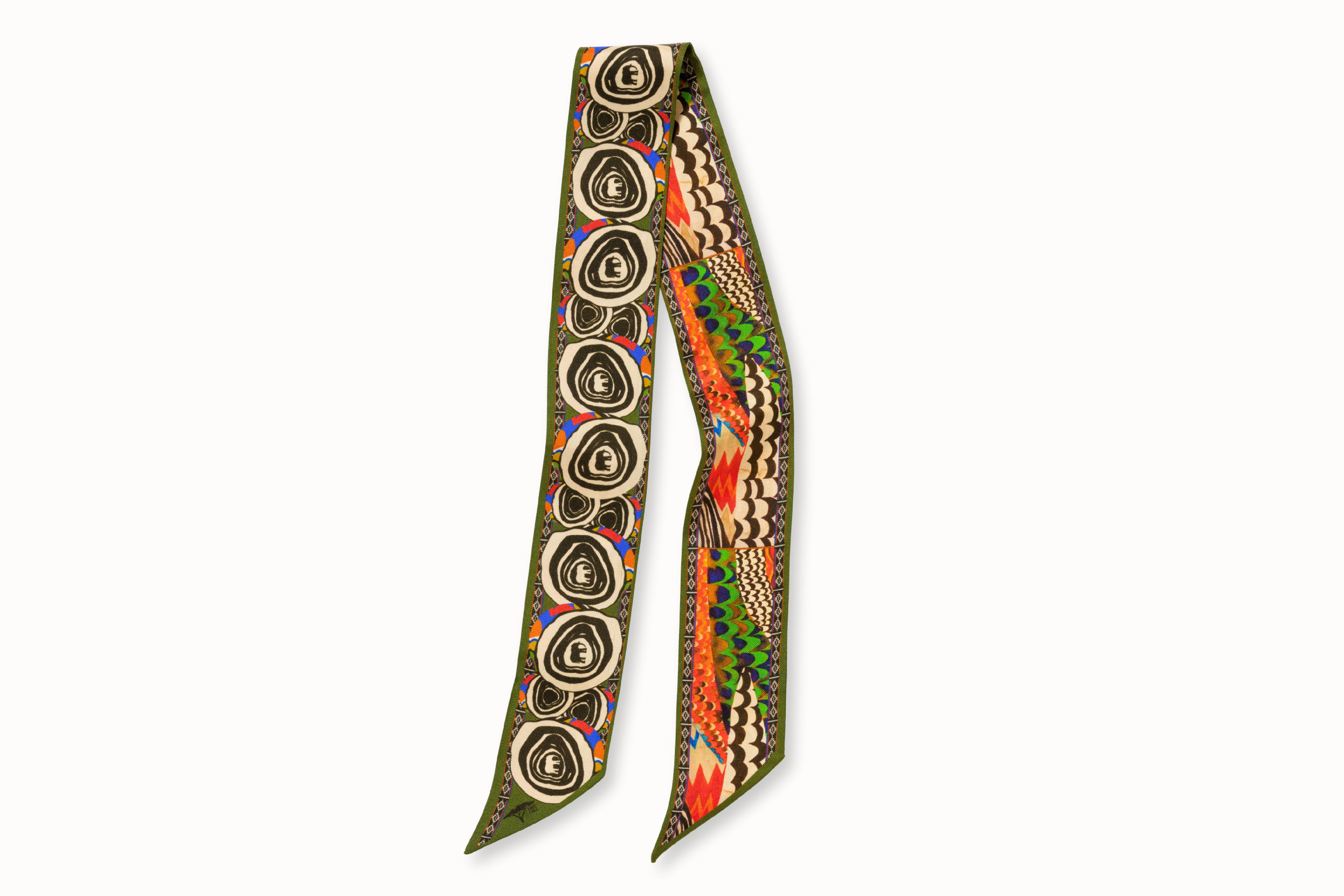 Flatlay image of 100% silk ribbon style scarf, 2” wide by 32” long. Featuring an abstract elephant motif and a pattern inspired by a traditional African painting composed of orange, army green, and hints of blue.