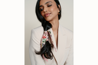 Image of female model wearing the scarf wrapped around her hair and tied in a simple knot. Model is wearing a neutral blazer.