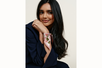 Image of female model wearing the scarf wrapped around her wrist and tied like a silk bracelet. Model is wearing a navy coord.