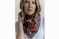 Image of female model wearing scarf folded into a triangle wrapped around and tied in the front of her neck.