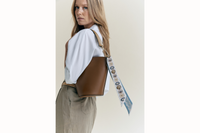 Image of model with bag over her shoulder with the scarf draping off the handle.