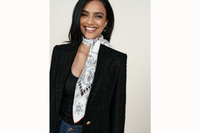 Image of female model wearing a black blazer and dark denim with the black and white version of Aristofreak scarf styled as a necktie.