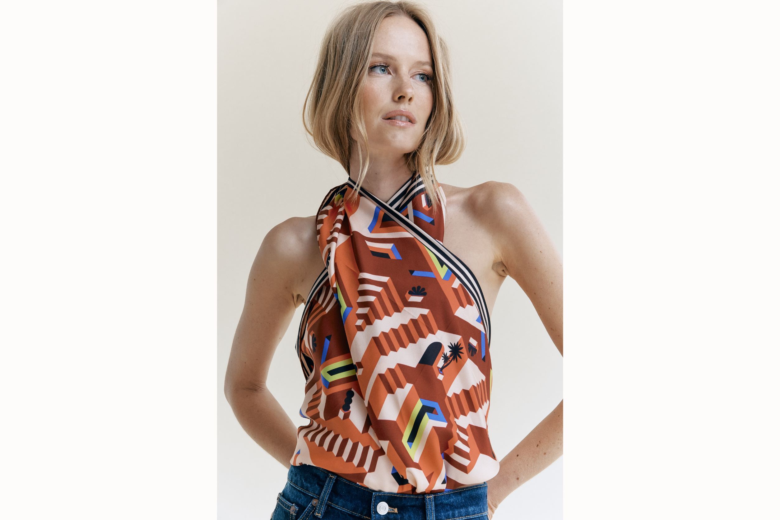 Image of female model wearing scarf tied together at the neck and bottom of the back to create a top. 