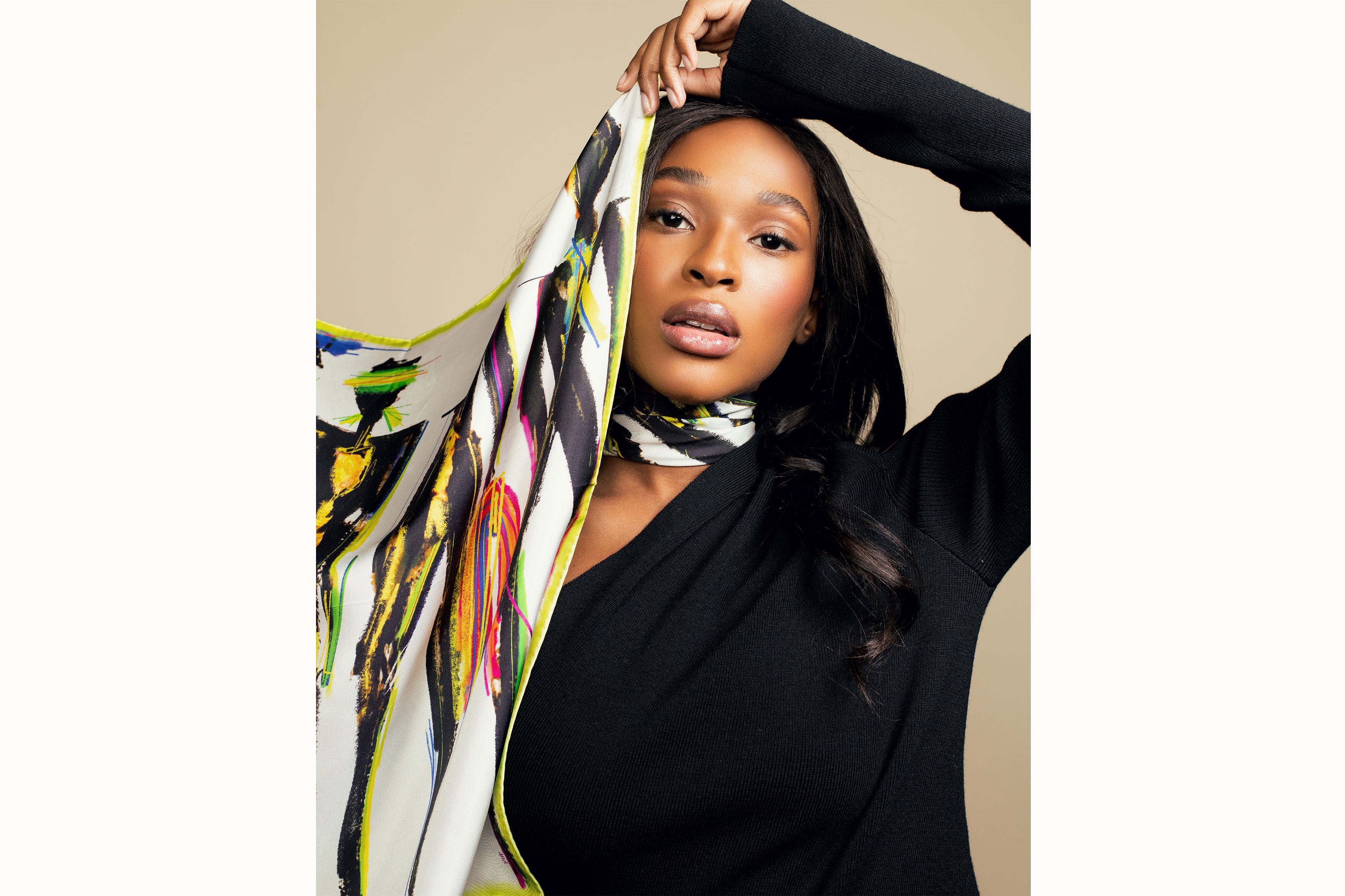 model holding up patterned scarf