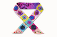Flatlay image of 100% silk ribbon style scarf, 2” wide by 32” long, wrapped in a collar shape so both sides of the scarf are seen. Design features a series of brightly colored flowers in shades of pink, blue, green and yellow and an abstract close-up of a purple and yellow flower petal on the other.