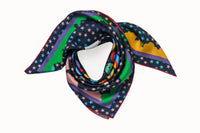 Rolled image of 100% silk square scarf featuring a motif of brightly colored stars, clouds and white moon phases throughout. The center features colorful geometric shapes as a compliment to the celestial theme.