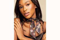 Image of female model wearing the scarf tied around her neck and secured with a simple knot, with the ends of the scarf draped down her chest. The model is also wearing a chocolate brown silk tank top.