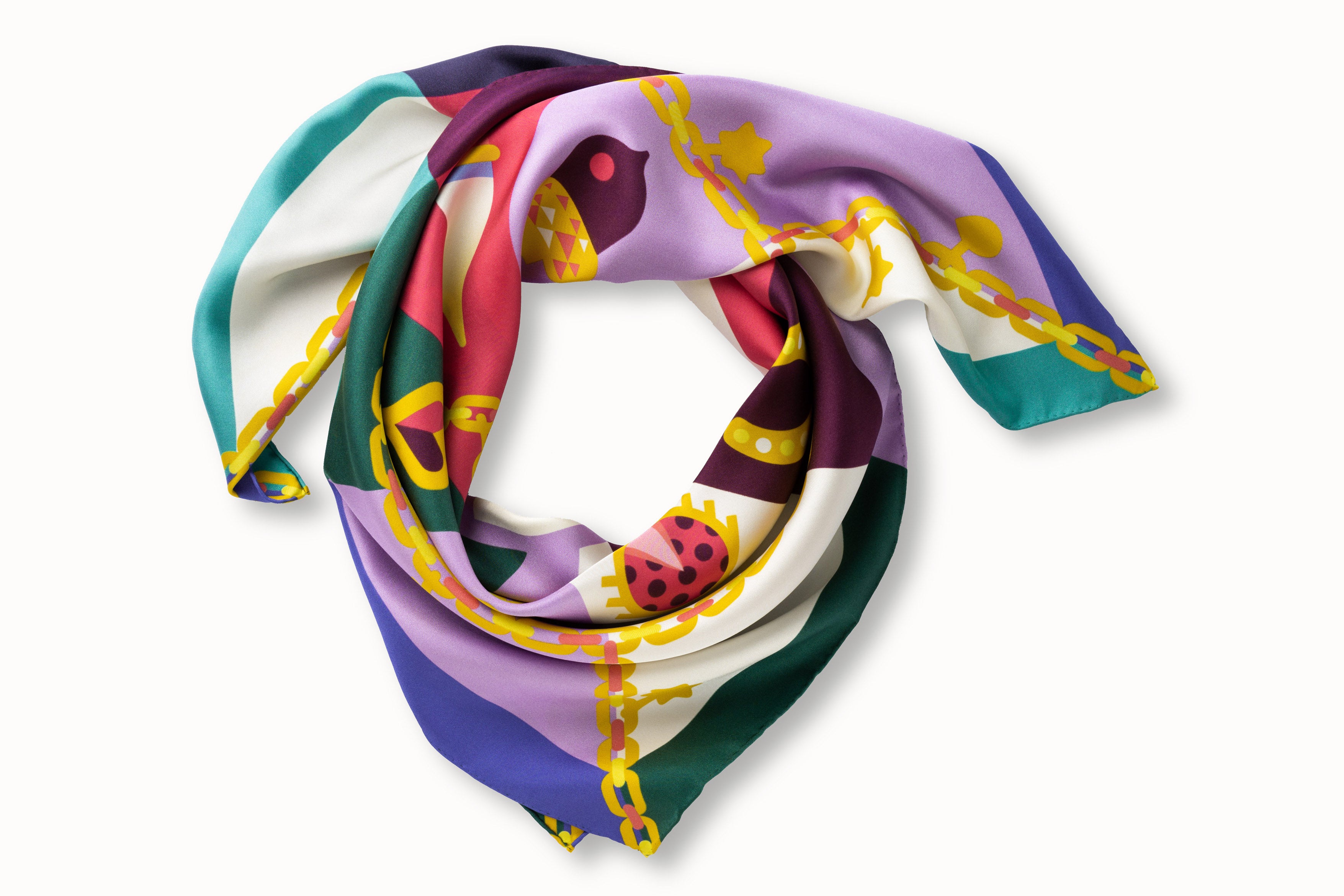 Rolled image of 100% silk square scarf featuring a motif of jewel toned good luck charms such as ladybugs, horseshoes, four leaf clovers, wishbones on a large gold chain with the evil eye symbol at the center.