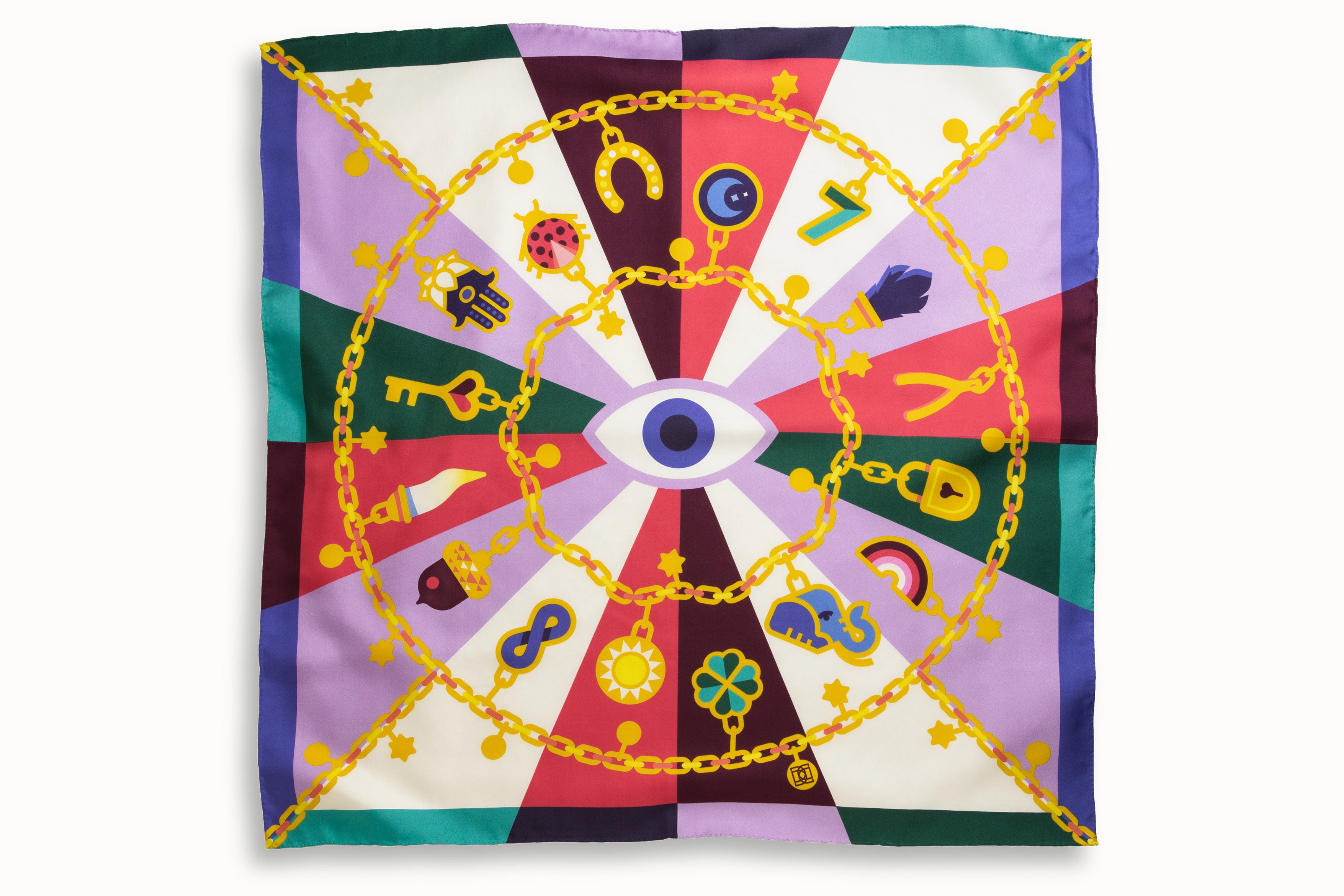 Flatlay image of 100% silk square scarf featuring a motif of jewel toned good luck charms such as ladybugs, horseshoes, four leaf clovers, wishbones on a large gold chain with the evil eye symbol at the center.