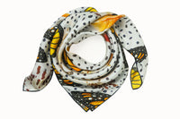 Rolled image of 100% silk square scarf featuring a motif of large-scale illustrated monarch wings and milkweed plants on a white background with imperfectly shaped black polka dots. Thin black border on the scarf.