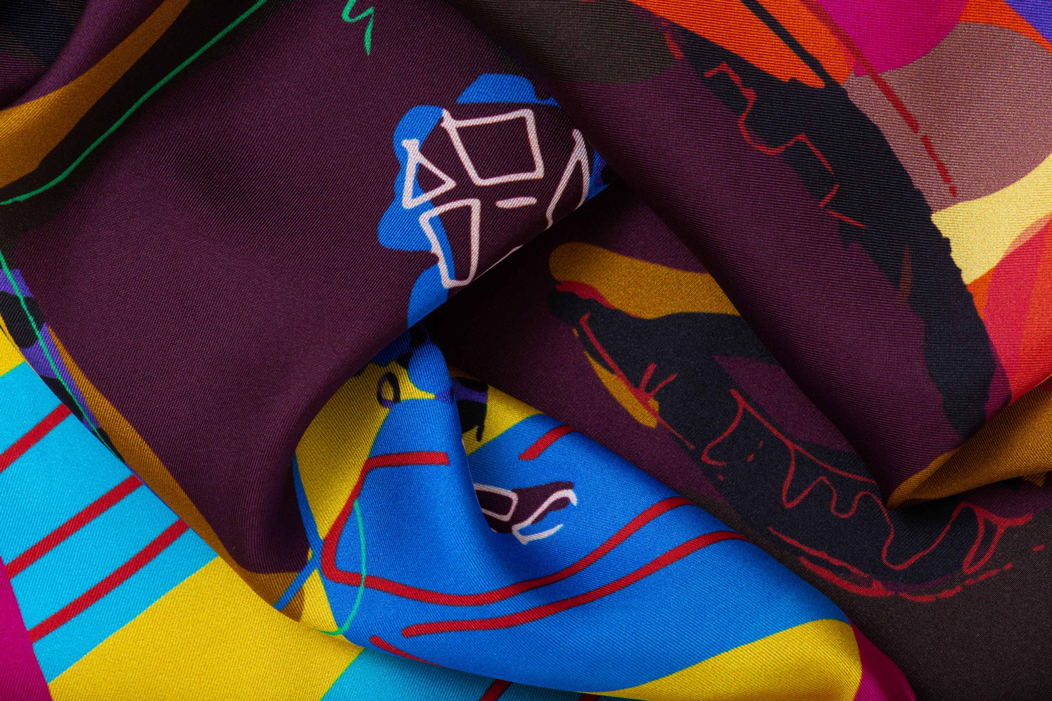 Close-up image of 100% silk square scarf featuring the artist’s portrait of Nina Simone surrounded by bold geometric shapes and featuring such colors as tangerine, citrus yellow, bright blue, burgundy and deep mahogany.