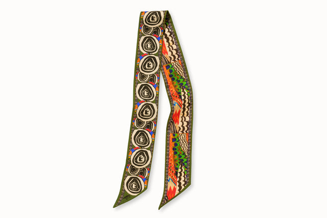 Flatlay image of 100% silk ribbon style scarf, 2” wide by 32” long. Featuring an abstract elephant motif and a pattern inspired by a traditional African painting composed of orange, army green, and hints of blue. 