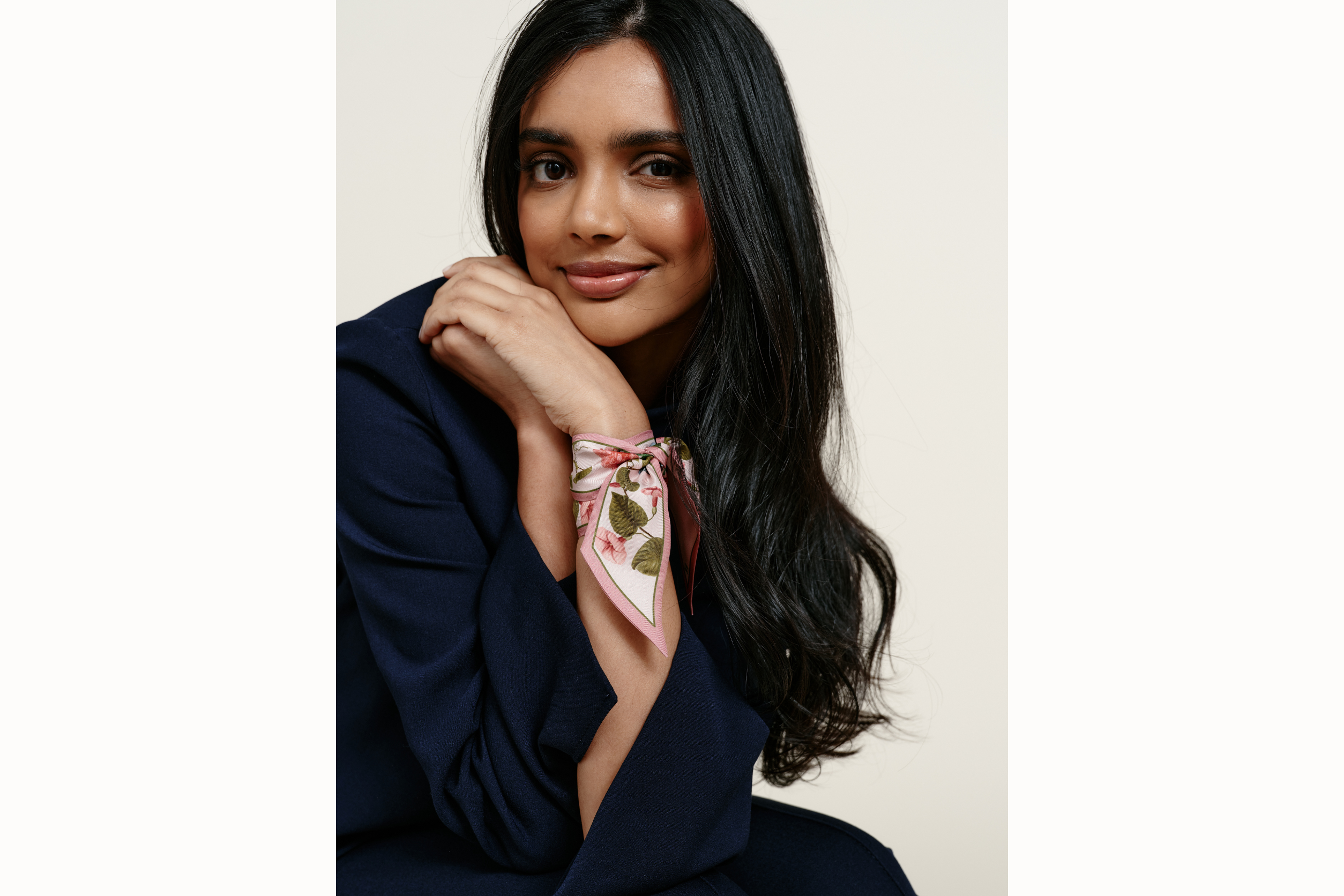  Image of female model wearing the scarf wrapped around her wrist and tied like a silk bracelet. Model is wearing a navy coord.