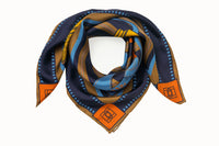 Rolled image of 100% silk square scarf featuring a motif of two large-scale illustrated film cameras and their straps splashed on top of a multi-color striped background. Blue film-inspired border around scarf. Design features colors such as orange, navy, camel, maize and a touch of aqua.