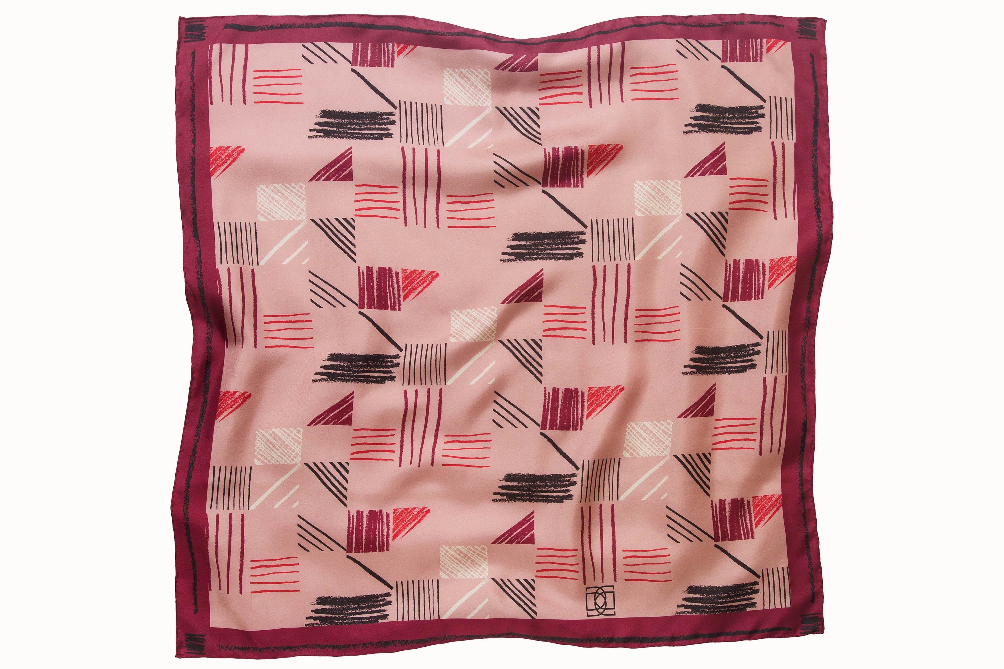 Flatlay image of 100% silk square scarf featuring a motif of charcoal, cherry, raspberry and cream colored imperfect lines making geometric rectangle and triangle shapes throughout the scarf. Blush pink background and rich berry colored border on the scarf.