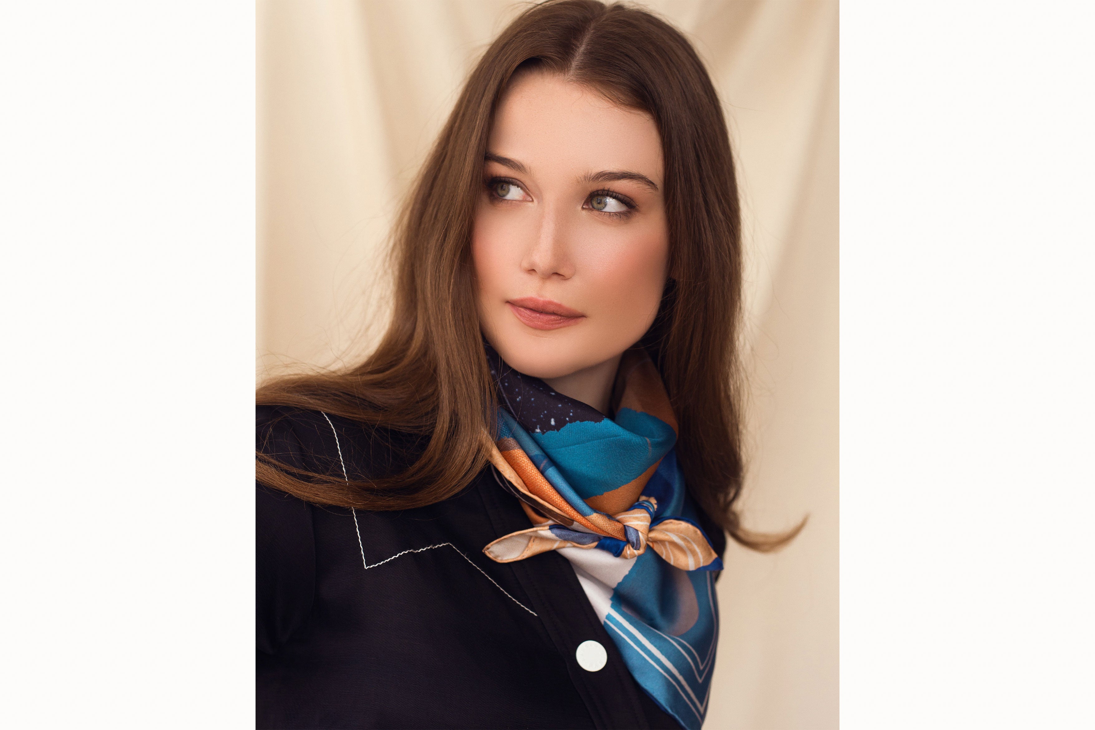 Woman wearing scarf tied around her neck wearing a blue blazer