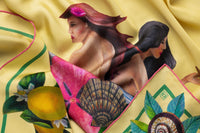Close-up image of 100% silk square scarf featuring two painted two mermaids resting on large sea shells, a pink flower and green seaweed on a lemon yellow background with small butterfly accents. Thin green border around the edges of the scarf, layered with green leaves, seashells and lemons. Ilustrates the lightly ridged texture of the silk twill along with the rich color tones and luminous nature of the silk scarf.